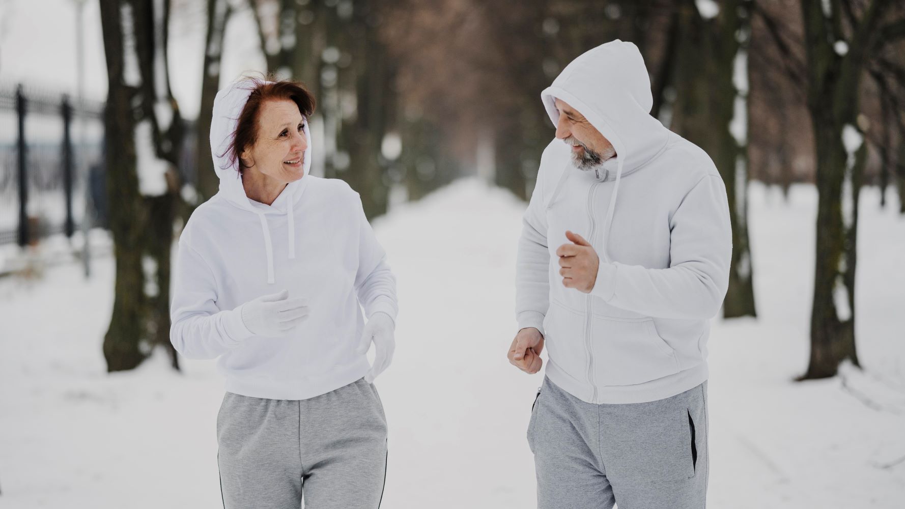 Du žmonės sportuoja apsnigtame parke